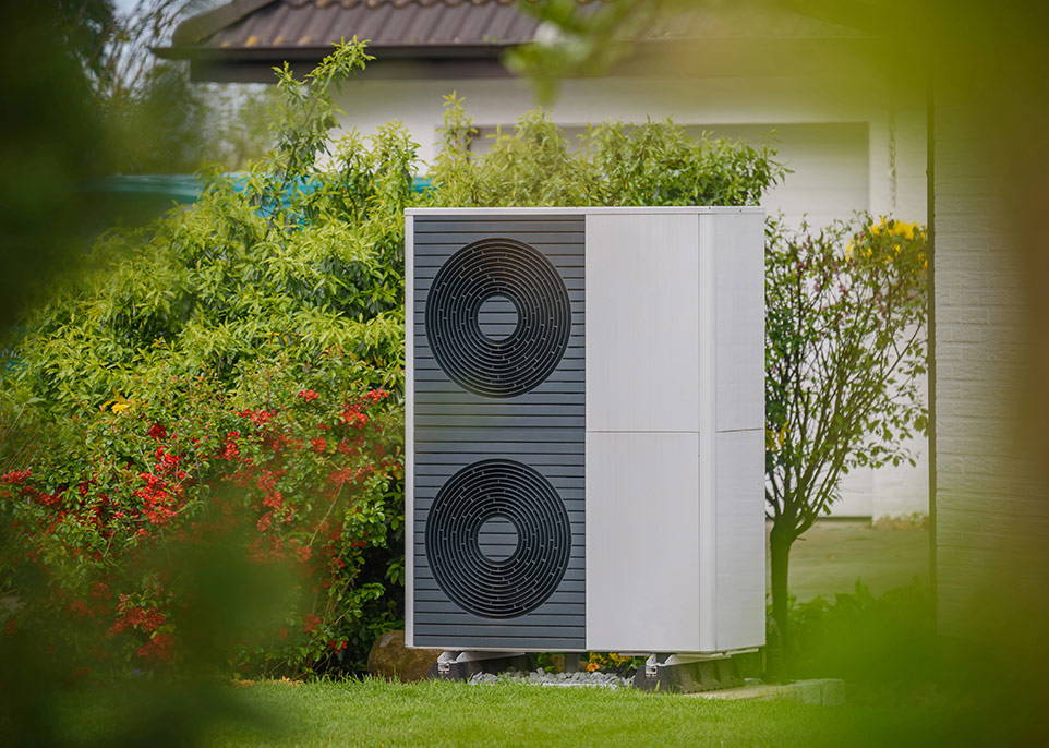 An image of a heat pump in a yard area.